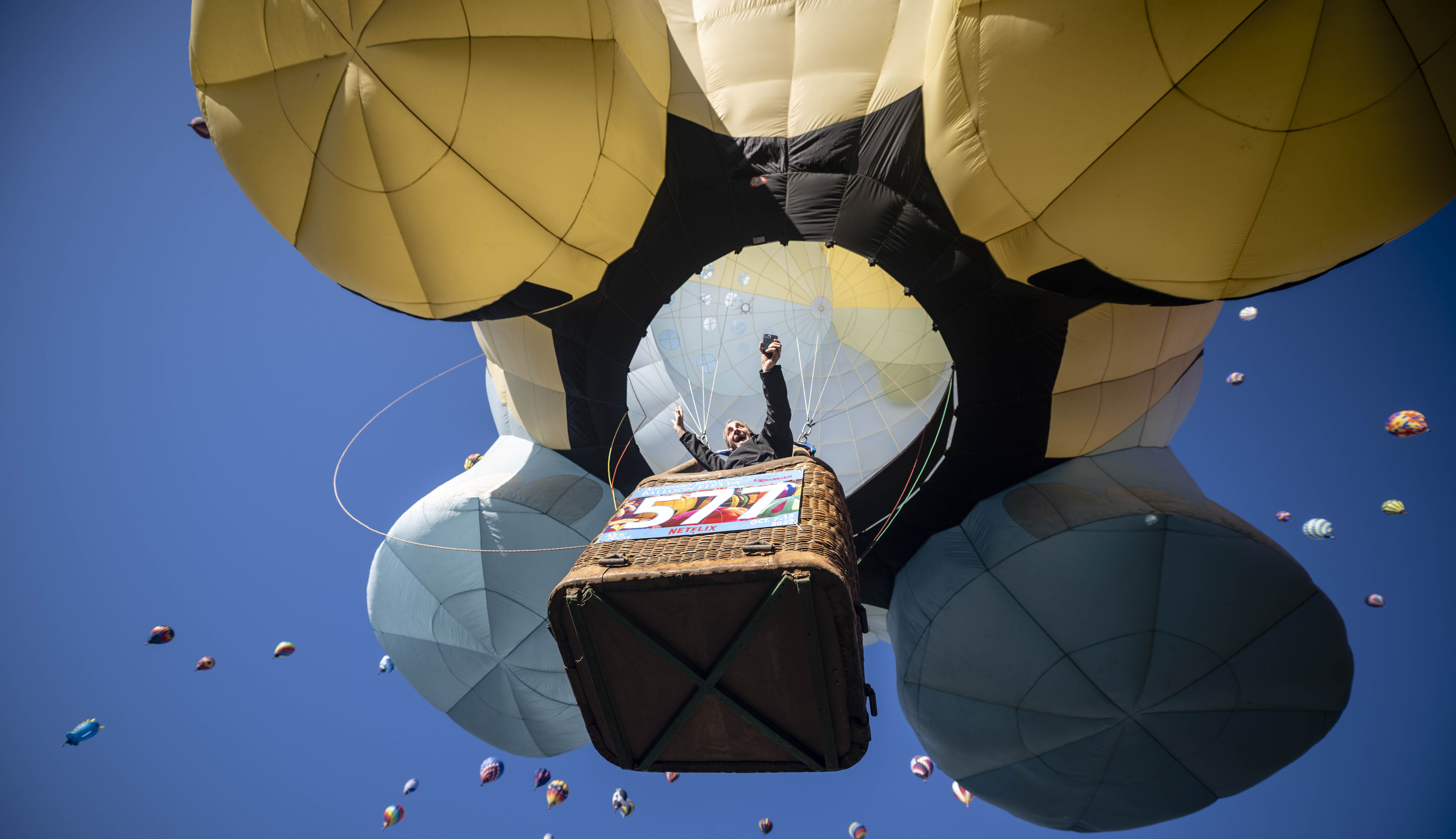 Pilot Pilip Audenaert, of Brazil, rejoices as he takes off during the mass accession at the Albuquerque International Balloon Fiesta, Saturday, Oct. 7, 2023, in Albuquerque, N.M. (AP Photo/Roberto E. Rosales)