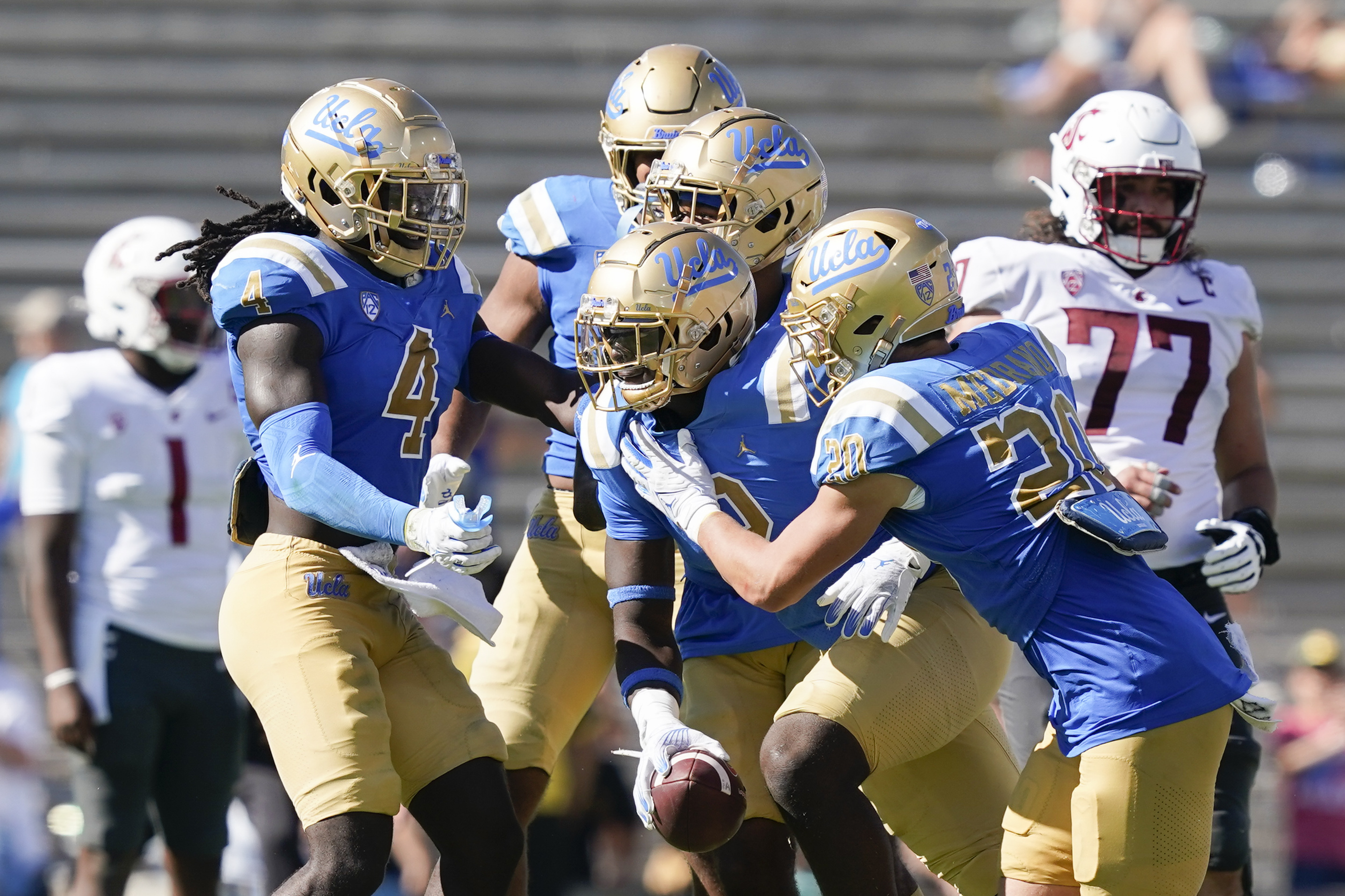 UCLA linebacker Oluwafemi Oladejo, center, is surrounded by teammates after intercepting a pass from Washington State quarterback Cameron Ward during the second half of an NCAA college football game, Saturday, Oct. 7, 2023, in Pasadena, Calif. (AP Photo/Ryan Sun)